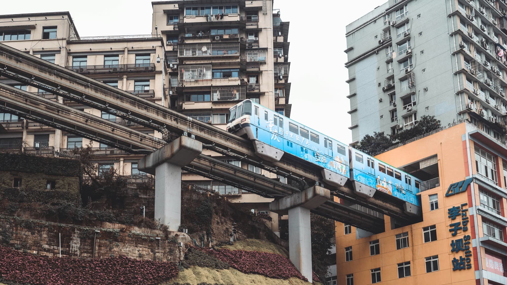 A Chongqing, alla stazione di Liziba, il treno della metropolitana attraversa un palazzo.